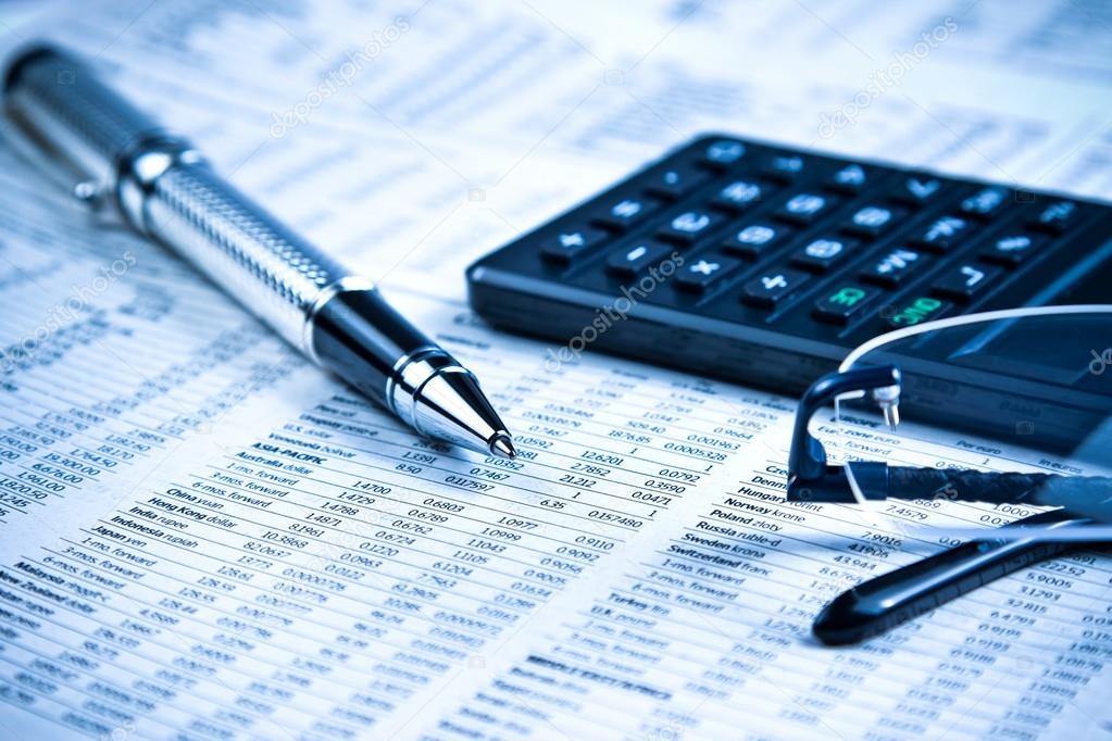 business fountain pen, calculator and glasses on financial chart 