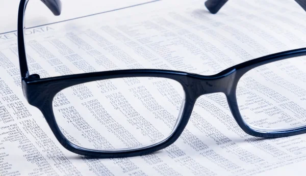 Relatório de jornal financeiro de negócios ver através de lentes de óculos, local de trabalho do empresário — Fotografia de Stock