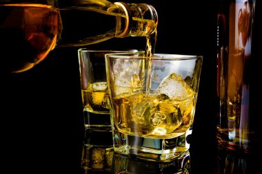 Barmen önünde viski bardak ve şişe viski yağıyor
