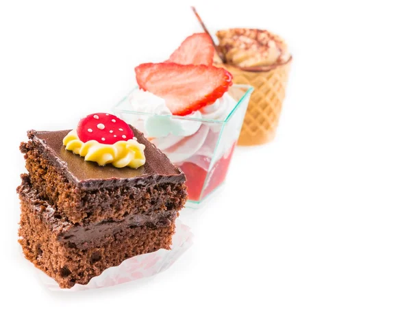 Deliziosa torta al cioccolato davanti a poco caffè e torte alla fragola su bianco — Foto Stock