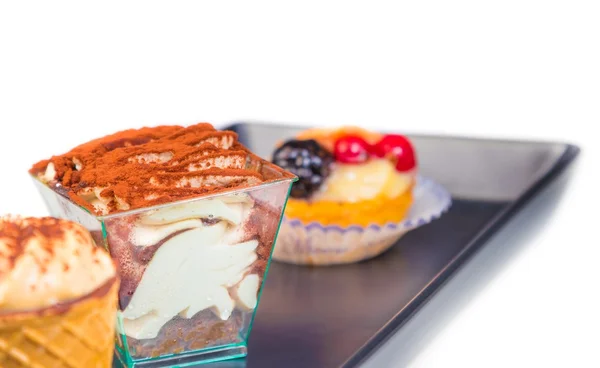 Delicious tiramisu cake near little cakes — Stock Photo, Image