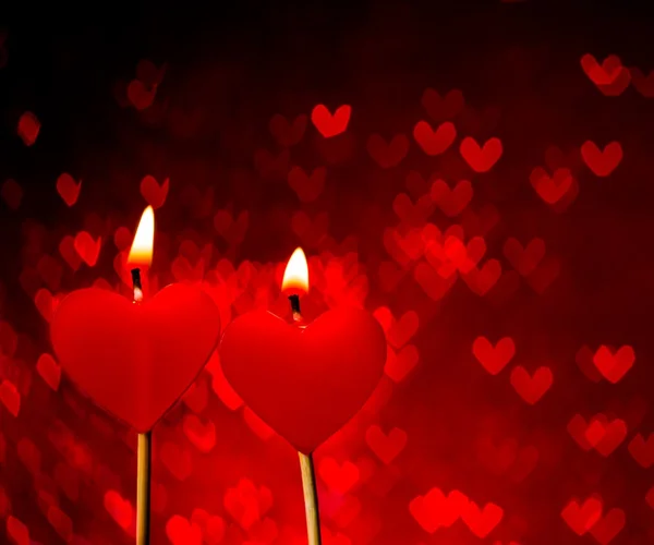 Red hearts candles on red hearts bokeh as background — Stock Photo, Image