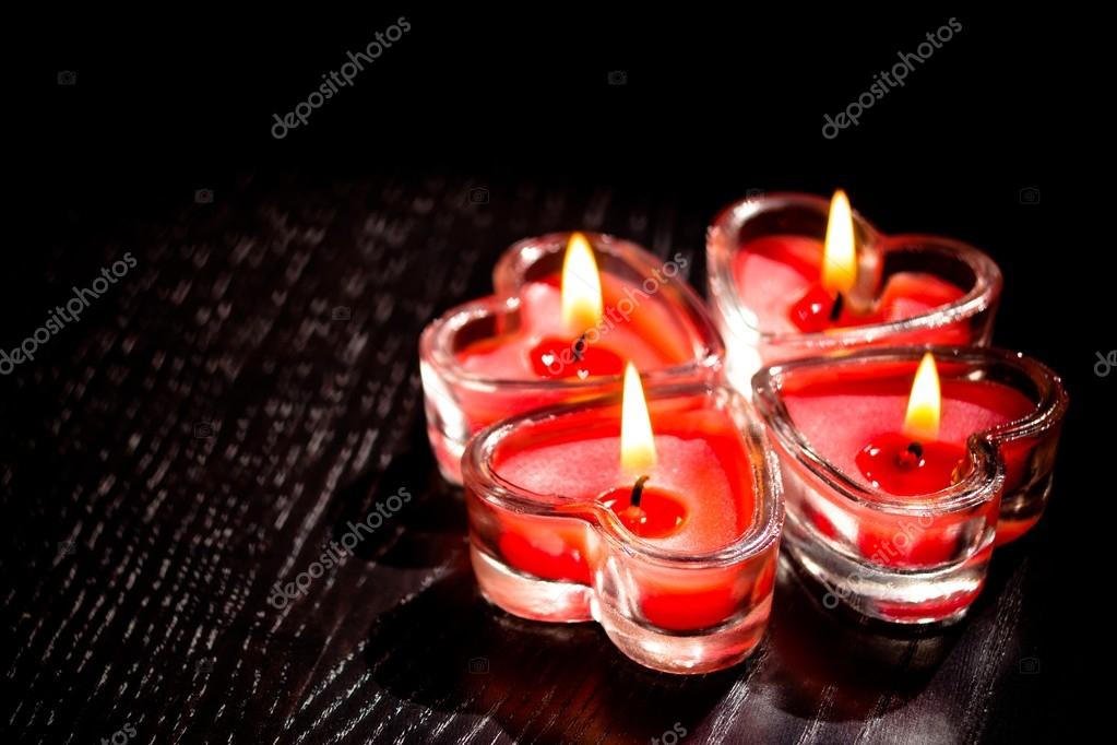 Burning heart shaped candle over red background, Stock image