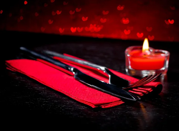 Ajuste de mesa de día de San Valentín con cuchillo, tenedor, vela en forma de corazón ardiente rojo —  Fotos de Stock