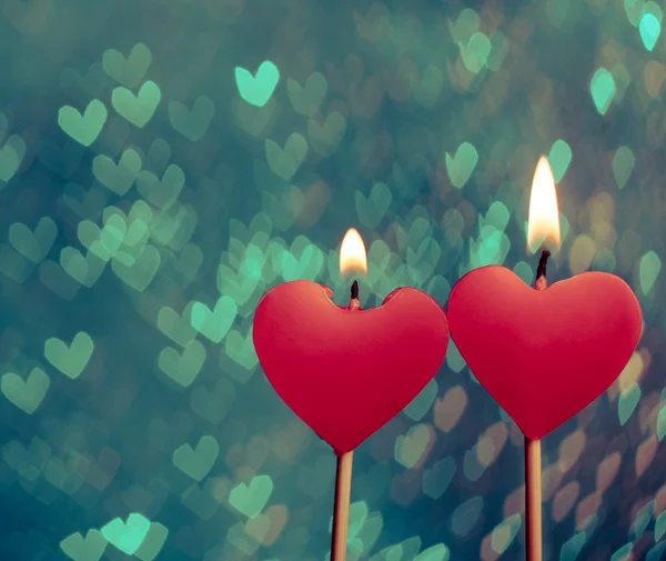 Rojo corazones velas en vintage corazones bokeh como fondo —  Fotos de Stock