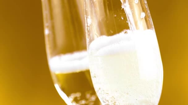 Flauti di champagne con bollicine dorate su fondo dorato — Video Stock