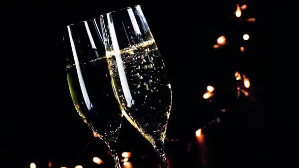 Due flauti champagne con bolle d'oro su sfondo nero chiaro scuro — Video Stock