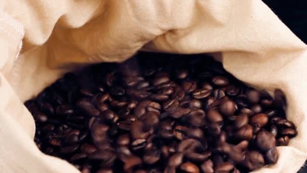 A lot of coffee beans falling down in a canvas sack, vintage style — Stock Video