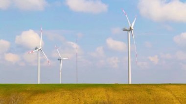 Rüzgar enerjisi türbinleri bir beyaz bulutlar ile mavi gökyüzünün altında en temiz, yenilenebilir elektrik enerji kaynağının vardır