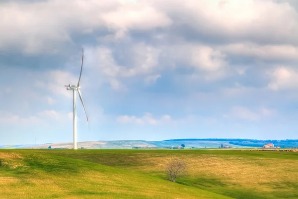 Turbina de energía eólica son una de las fuentes de energía eléctrica más limpias y renovables, bajo el cielo azul con nubes blancas —  Fotos de Stock