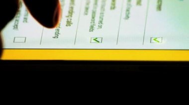 Tablet pc bilgisayar ipad dokunmatik ekran üzerinde onay kutularını seçmek için parmak kullanan adam