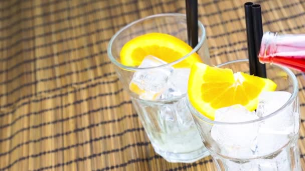 Barman gieten rode spritz aperitief aperol cocktail met twee oranje segmenten en ijsblokjes — Stockvideo