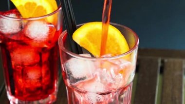 Barmen yağan kırmızı spritz aperatif aperol iki portakal dilimleri ve buz küpleri ile kokteyl