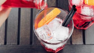 Turuncu dilimler ve buz küpleri ile dökülen kırmızı spritz aperitif aperol kokteyl görünümü üst