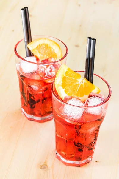 Dos vasos de aperitivo spritz cóctel aperol con rodajas de naranja y cubitos de hielo en la mesa de madera — Foto de Stock