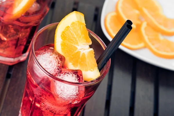 Närbild av beskådar glasögon av aperol spritz aperitif cocktail med apelsinskivor och isbitar — Stockfoto