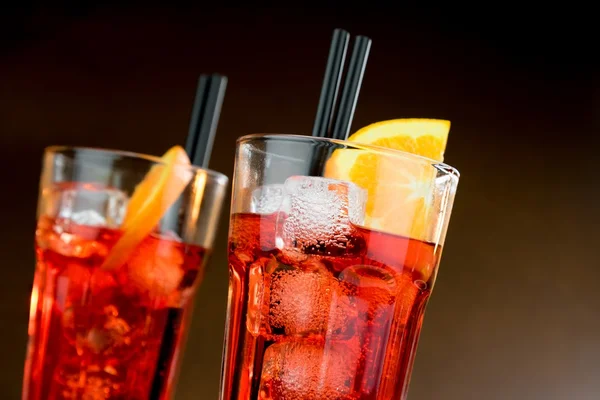 Два стакана коктейля аперитива с апельсиновыми ломтиками и кубиками льда — стоковое фото