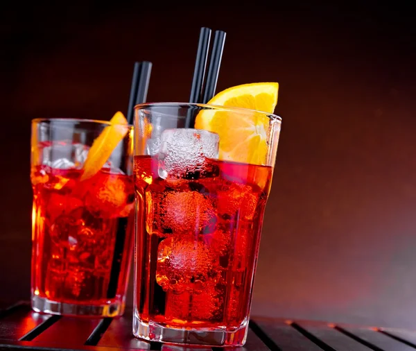 Spritz aperitivo aperol cóctel con rodajas de naranja y cubitos de hielo sobre fondo degradado de color —  Fotos de Stock