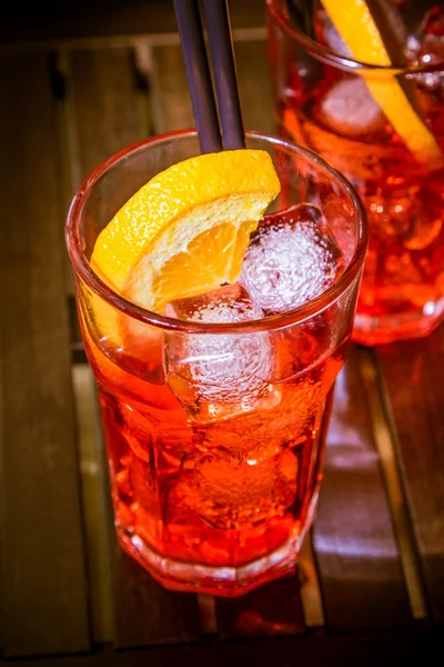 Spritz aperitif aperol cocktail with orange slices and ice cubes on color disco light background — Stock Photo, Image