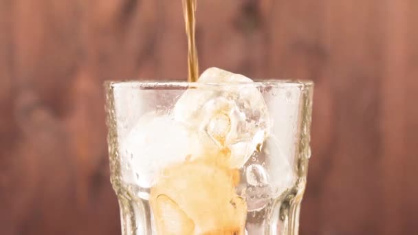 verser du coke frais avec des glaçons isolés sur fond de bois 