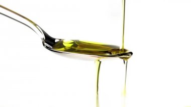 Sızma zeytinyağı bir kaşık beyaz arka plan üzerinde izole üzerinden dökme