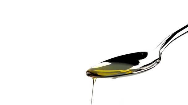 Extra virgin olive oil over a spoon with drops isolated on white background — Stock Video