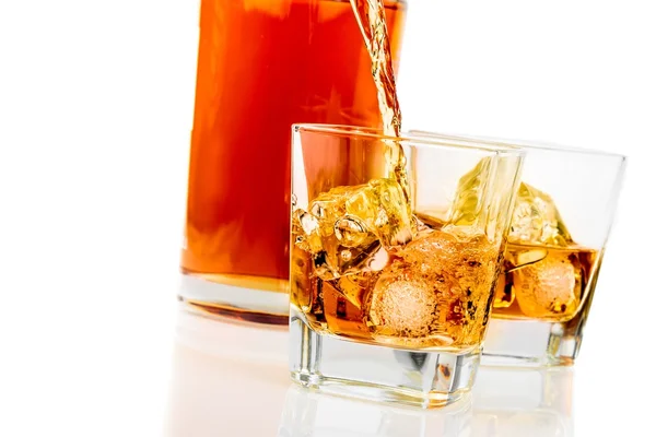 Whiskey in the glasses in front of bottle on white background — Stock Photo, Image