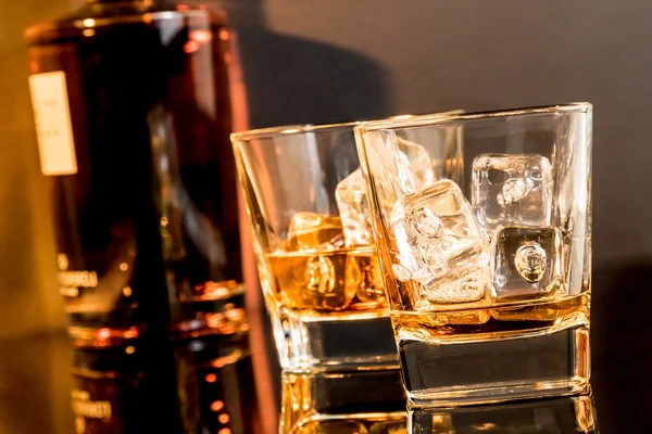 Två glas whiskey framför whisky flaska — Stockfoto