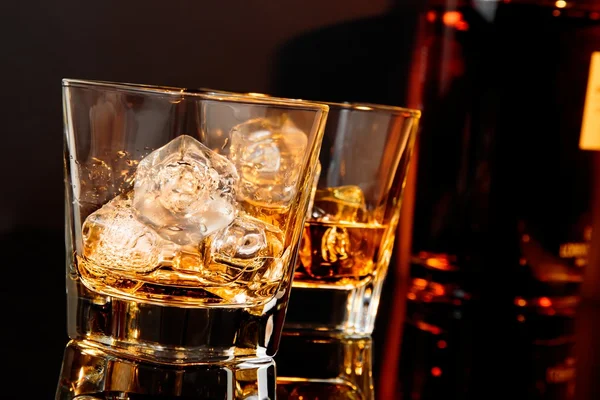 Dwie szklanki whisky przed butelka whisky — Zdjęcie stockowe
