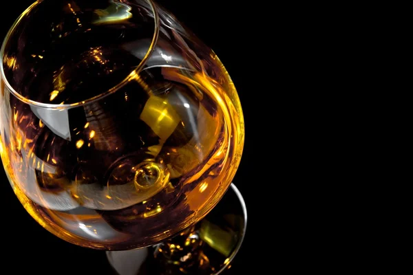 Snifter of brandy in elegant typical cognac glass on black background — Stock Photo, Image