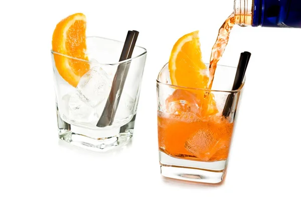 Barman gieten spritz aperitief aperol cocktail in twee glazen met stukjes sinaasappel en ijsblokjes — Stockfoto