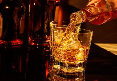 Barmen önünde viski cam ve şişe viski dökme