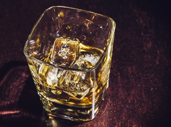 Cima di vista di vetro di whisky su tavolo di legno, atmosfera calda — Foto Stock