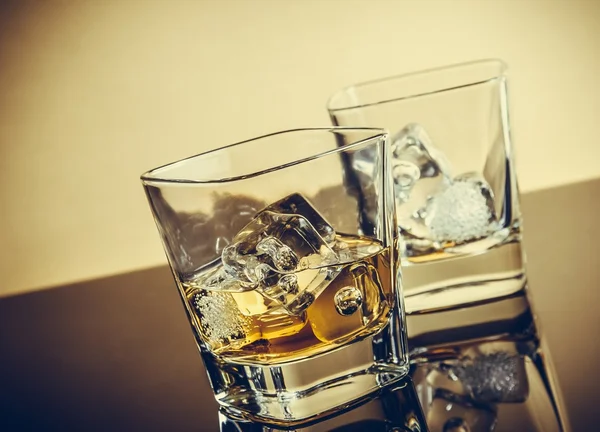 Två glas whiskey på bord med reflektion, varm atmosfär — Stockfoto