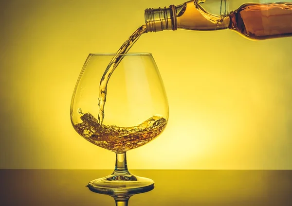 Barman verter snifter de brandy en elegante vidrio de coñac típico en la mesa — Foto de Stock