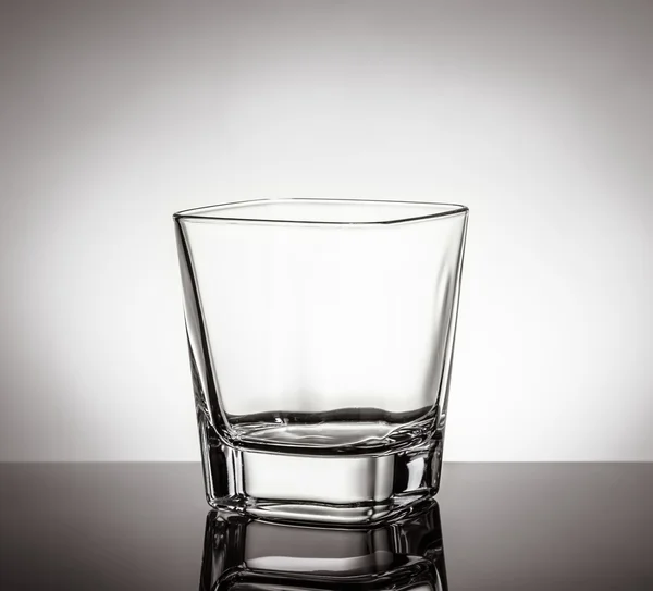 Vaso vacío de whisky sobre mesa negra con reflejo sobre fondo blanco —  Fotos de Stock