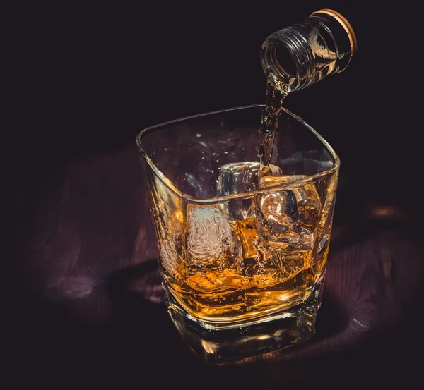 酒保倒威士忌在玻璃上木桌，气氛热烈，旧的西方风格，时间的放松与威士忌 — 图库照片