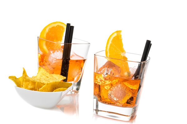 two glasses of spritz aperitif aperol cocktail with orange slices and ice cubes near tacos chips