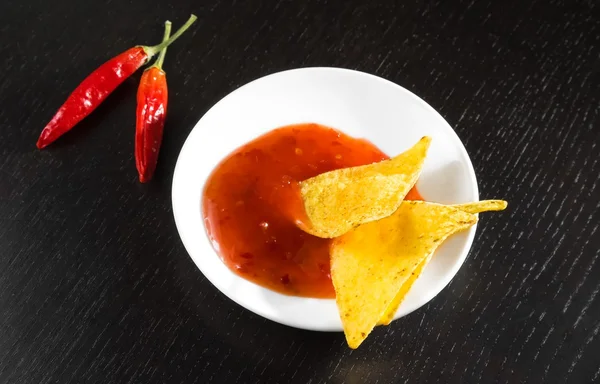 Crisp corn nachos with spicy hot tomato sauce as a snack or appetizer in a white disc — Stock Photo, Image