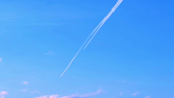 Trazas de vapor de avión a través del cielo azul claro con nubes — Vídeo de stock