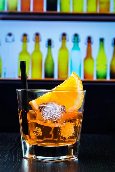 Kieliszek aperol aperitifem spritz koktajl z plastrami pomarańczy i kostki lodu na pasku tabela, disco bar w salonie atmosfera tła — Zdjęcie stockowe