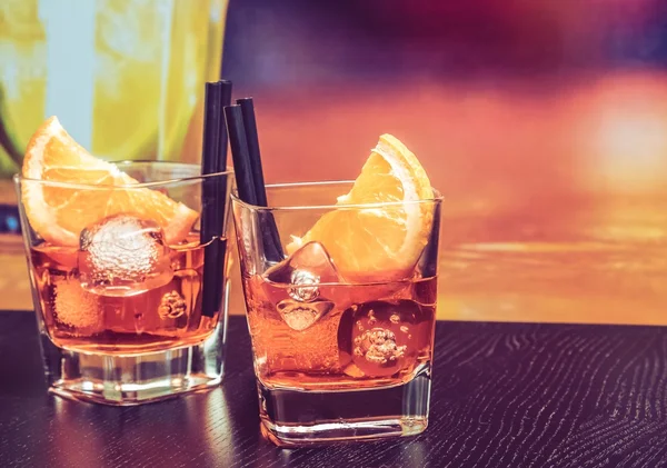 Vasos de spritz aperitivo aperol cóctel con rodajas de naranja y cubitos de hielo en la mesa de bar, ambiente vintage fondo —  Fotos de Stock