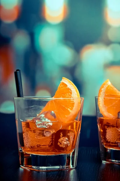 Copos de aperitivo aperol cocktail spritz com fatias de laranja e cubos de gelo na mesa de bar, fundo atmosfera estilo pop — Fotografia de Stock