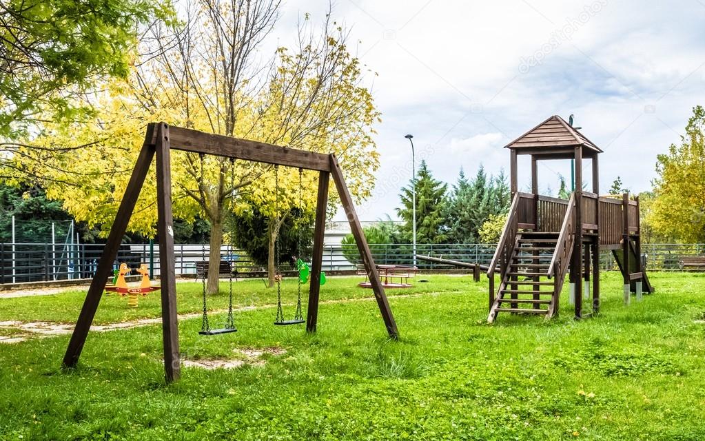 empty swings at playground for child near children stairs slides equipment