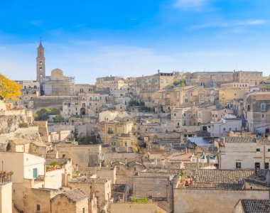 panoramik tipik taşlar (Sassi di Matera) ve kilise Matera mavi gökyüzü altında