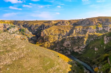 Rupestrian taşlar, tarihi bina. La Gravina di Matera. Basilicata mavi gökyüzü altında