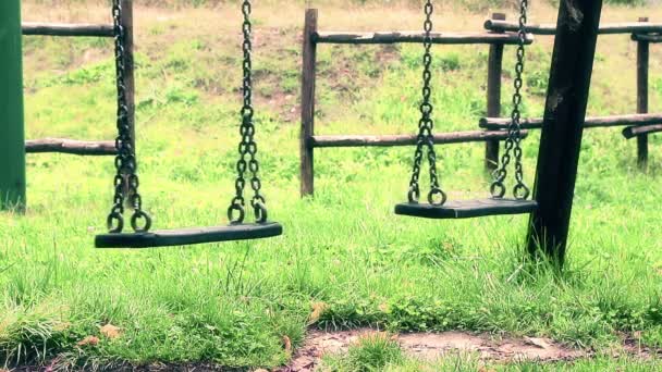 Prázdné staré ročník houpačky s řetězy kýval na hřiště pro děti, přestěhoval z větru, zpomalené vintage styl — Stock video
