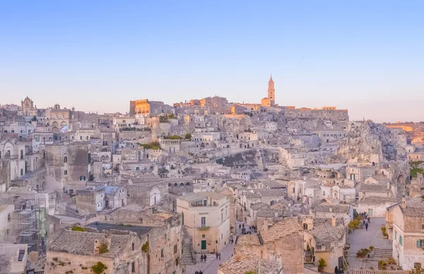 Panoramatický pohled typické kamenů a kostel Matera a Madonna de Idris pod začít při západu slunce obloha — Stock fotografie