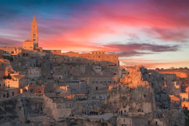 panoramik tipik taşlar ve Matera kilise ve Madonna de Idris günbatımı gökyüzü altında