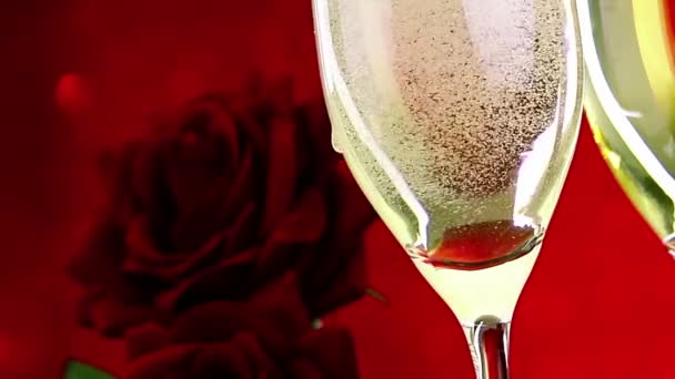 lití šampaňské flétny s bublin v blízkosti červené růže červené bokeh pozadí, láska a valentine den konceptu